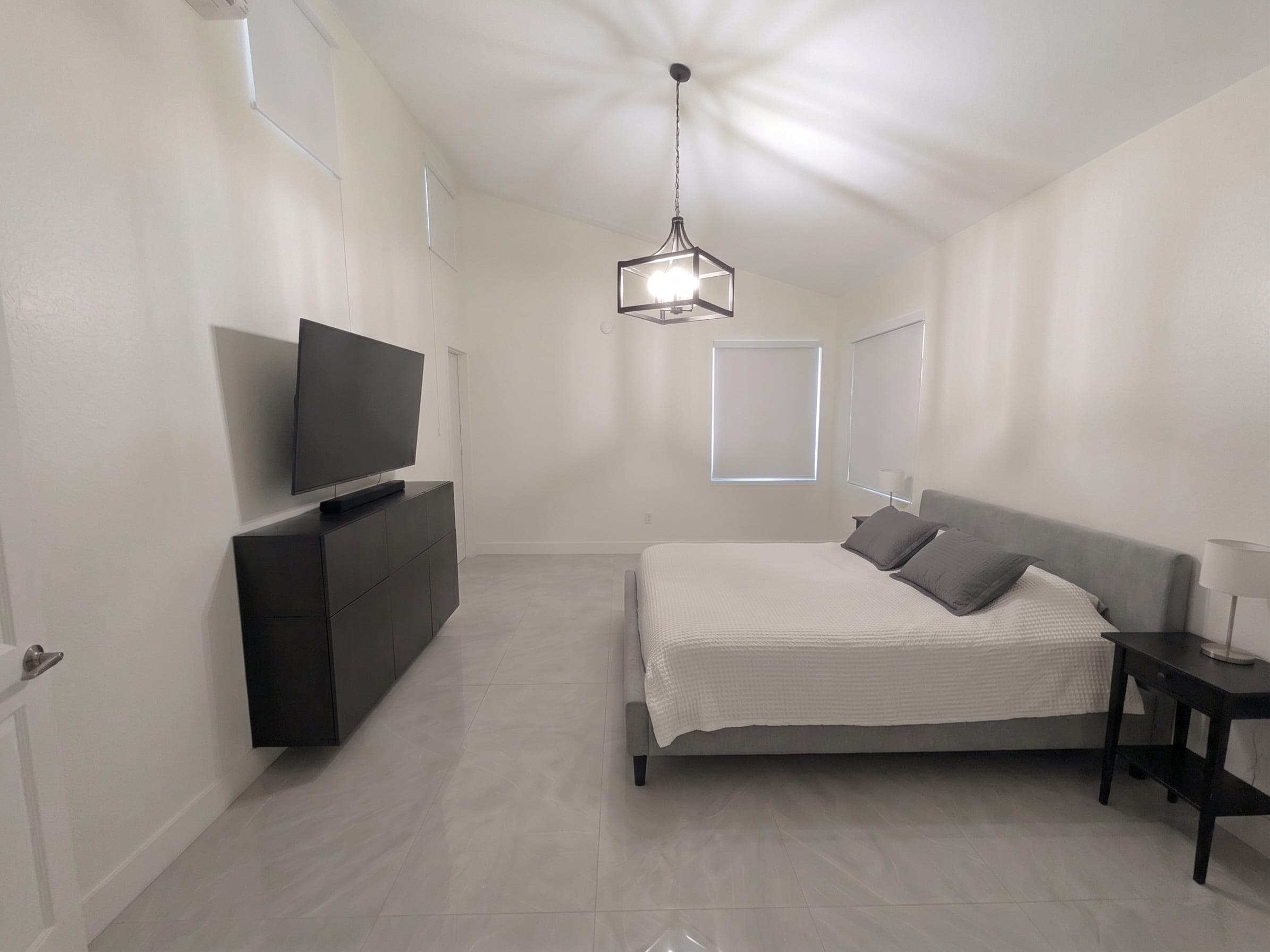 Primary bedroom with vaulted ceiling and pendant lighting