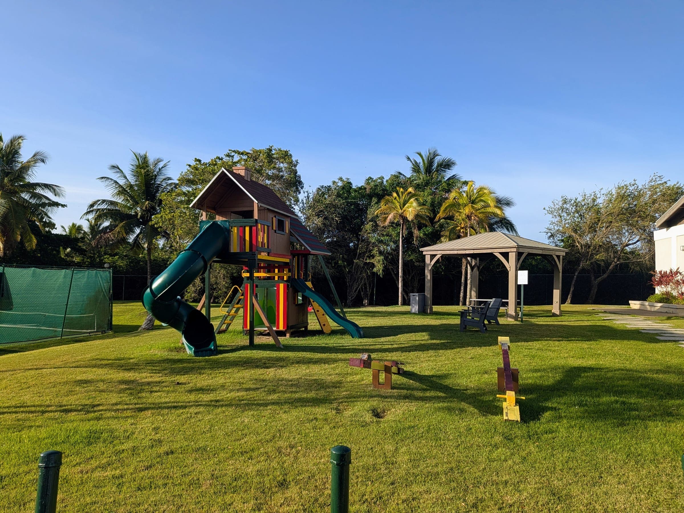 Community playground with wooden play structure and shaded gazebo