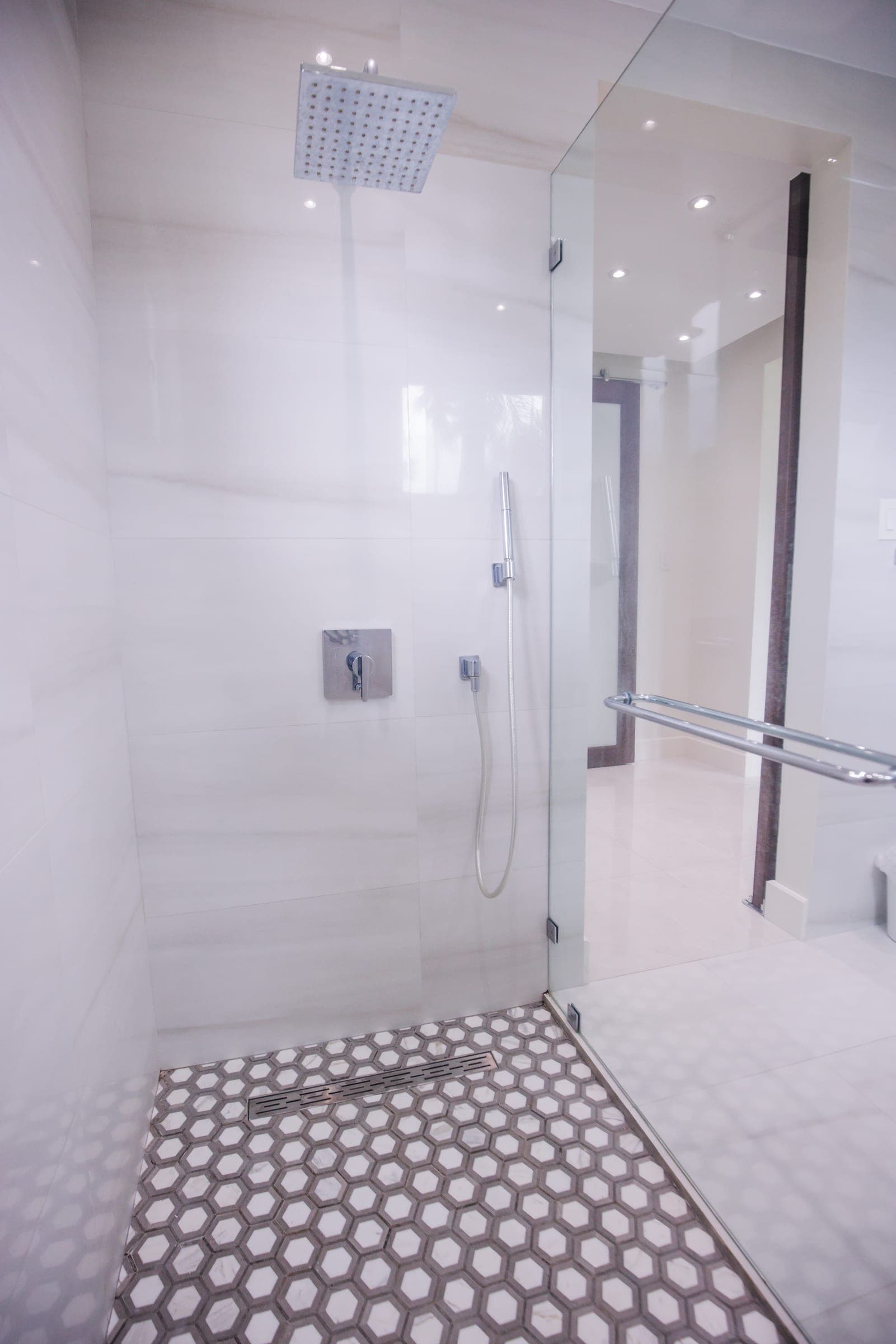 Primary bathroom with frameless glass walk-in shower and hex tile floor
