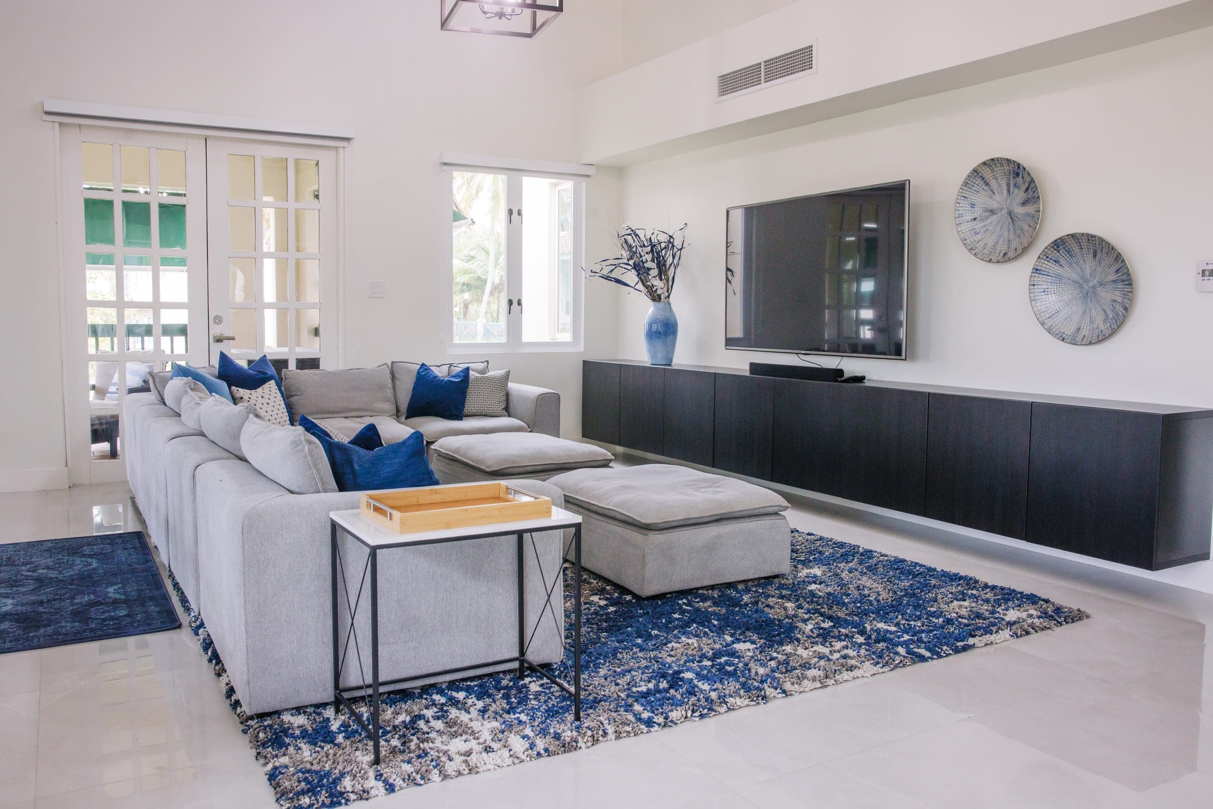 Living room with sectional, media console, and curated wall decor